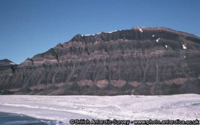 A person standing in front of a mountain.