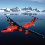 A plane flying over a body of water.